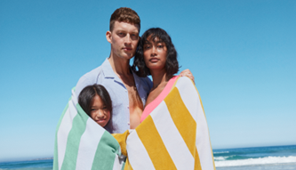 家庭三个裹着五颜六色的沙滩巾